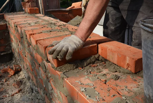 Industrial bricklayer photo. Bricklayer bricklaying brick wall. Masonry work close up.