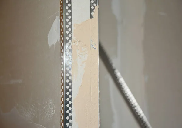 Drywall partition construction. Close up on  skim coating, finishing, applying the first coat of plaster on a drywall partition wall