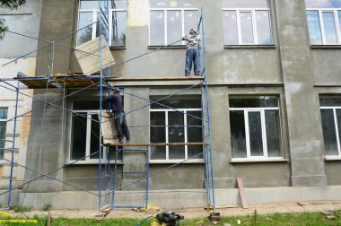 Building contractors are installing, assembling high scaffolding to renovate the facade of the building.