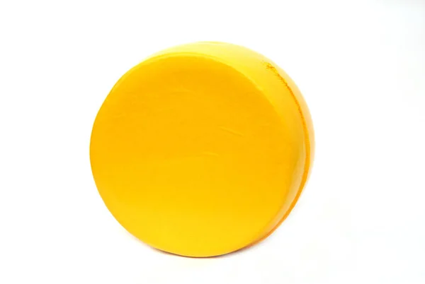 黄色いフィルムで丸めたチーズ 白い背景に黄色の丸みを帯びたチーズ チーズホイールラウンドイエロー — ストック写真