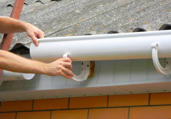雨具の設置 アスベストスの屋上の古い家の雨のガターパイプラインを修理し 改装する — ストック写真