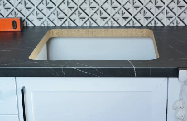 厨房水池的安装 新的厨房家具安装 其特写镜头包括厨房后飞溅和厨房工作台 工作台上有一个水槽的切割孔 — 图库照片#