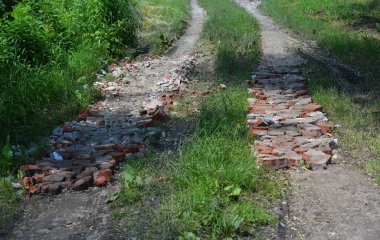 Kırık tuğlaları olan bir köy yolu. Kötü yol..