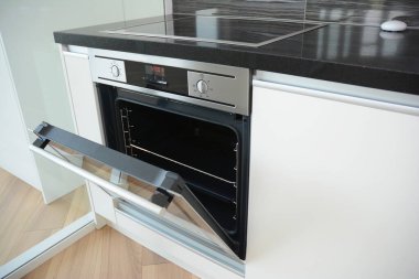 A close-up on a  radiant electric  ceramic glass top stove with a built-in electric stove integrated in a black and white kitchen table, countertop.