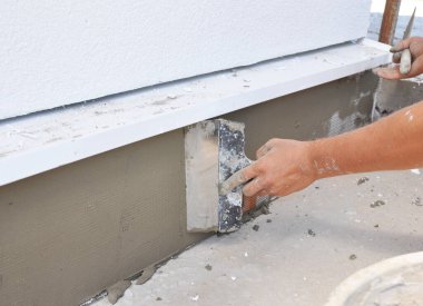 Müteahhit ev temellerini alçıdan örgü bandı ve köpükten izolasyon üzerine sıva yapıyor..