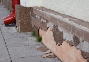 Bad house foundation waterproofing. House foundation repair caused by damp from rain gutter downspout pipe in problem area. House plinth foundation repair. clipart