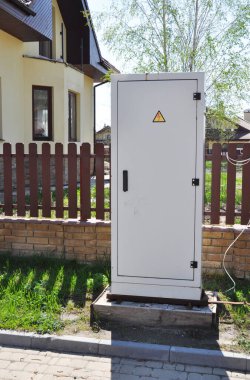 Elektrik kutusu, evin çitleri yakınında elektrik sayacı ölçümü. Caddedeki elektrik santralinin iç metal kontrol kutusunu kapat..