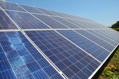 Güneş çiftliği, yerdeki güneş panelleri. Güneş panellerinin fotoğrafı yenilenebilir yeşil enerji konsepti olarak.