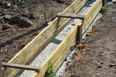 Beton zeminde beton taban. Tahta levhalara beton dök ve çit temeli olarak parmaklıkları destekle. Beton zemine yakın durun..