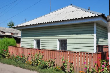 Eski ev cephesi ve plastik kaplama duvarlı ve asbest çatılı çatı tamiri. Kaplaması olan evi sil.