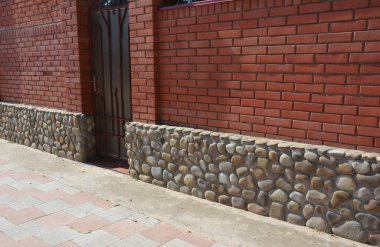 Vahşi kaya çiti temeli olan kırmızı tuğlalı ev çiti..