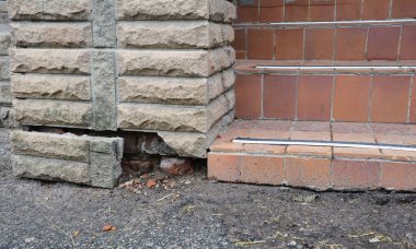 Evin giriş merdivenlerinin yakınındaki vakfın su geçirmez olmaması nedeniyle kırık bir ön cephe tuğlası..