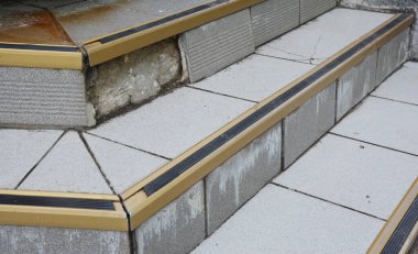 Kayma önleyici kaplamalı kırık beton giriş merdivenleri.