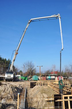 KYIV, UKRAINE - 20 Mayıs 2025: beton taban inşaatı. İnşaatçı kamyon karıştırıcı pompa tüpünden beton döküyor. Yeni bir evin beton temeli için kereste beton döküm..