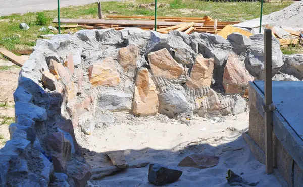 Bir evin duvarına yakın bir teras için vahşi taş temeli..