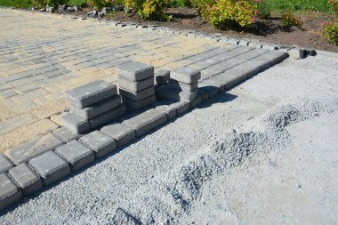 Evin yakınında veranda kaldırımı inşaatı var. Kaldırım tuğlaları yerleştiriliyor.