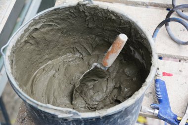 Evin dış sıvası için harç dolu bir kova.