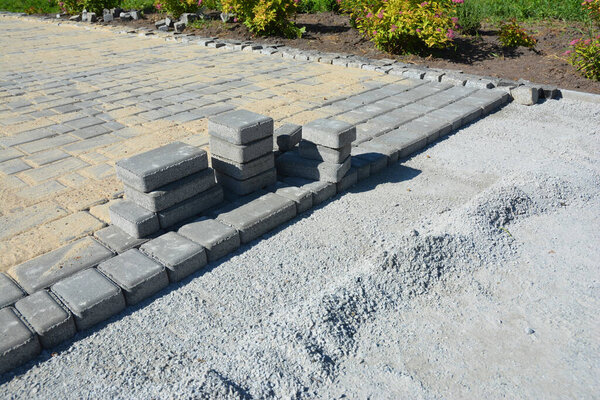 Рядом с домом построена тротуарная плитка. Укладка кирпича.