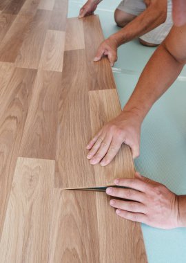 Laminate döşeme kuruluyor. İşçiler kat kaplaması kuruyor. Döşeme kurulumunu kapat.