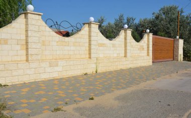 Çit, sokak manzaralı, aydınlatma ve otomatik kapılar için lambalı dekoratif tuğlalarla kaplı..