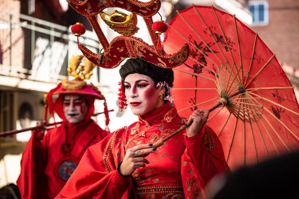 Madrid, Spain; 22nd January 2023: Chinese New Year parade in Usera neighborhood, Madrid. Spain. Close-up of a gheisa dressed in oriental costume with a red umbrella, wearing make-up and walking