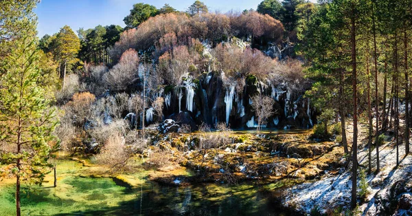 Cuervo nehrinin kaynağının panoramik görüntüsü, Cuenca, İspanya. Kışın sonu ve neredeyse ilkbaharda buzlar çözülecek. Kar ve buz sürükleniyor ve su toplayan bir göl. Çam ve yaprak döken ağaçlar