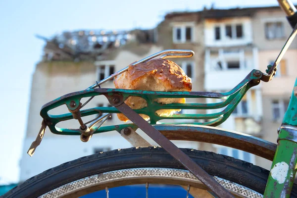 Stock image piece of bread on the trunk of an old bicycle. food and transport. poverty and survival in poor conditions