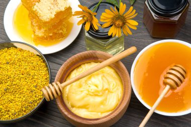 Farklı çeşitlerde taze çiçek balı, polen ve ahşap arka planda kaşıkları olan bal peteği. Organik Vitamin Sağlıklı Gıda