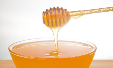 Taze kokulu bal bir kaşıktan bir tabağa damlıyor. Organik vitamin besin. Tatlı yemek.