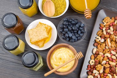 Tahta arka planda taze bal, fındık, çilek ve yaban mersini. sağlıklı organik vitamin yiyeceği.