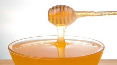 Taze kokulu bal bir kaşıktan bir tabağa damlıyor. Organik vitamin besin. Tatlı yemek.