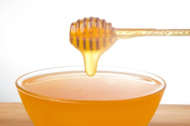 Taze kokulu bal bir kaşıktan bir tabağa damlıyor. Organik vitamin besin. Tatlı yemek.