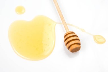 Beyaz arka planda taze bal dökülmüş kaşık. organik vitamin yiyeceği