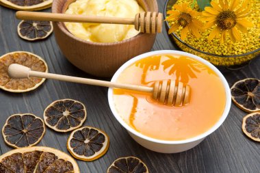 Farklı çeşitlerde taze çiçek balı, polen ve ahşap arka planda kaşıkları olan bal peteği. Organik Vitamin Sağlıklı Gıda