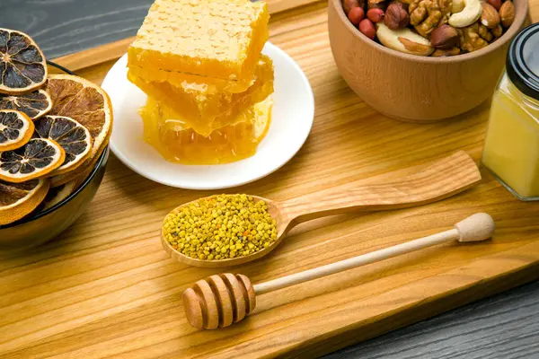 stock image Fresh flower honey of different varieties, pollen and honeycomb with spoons on a wooden background. Organic Vitamin Health Food