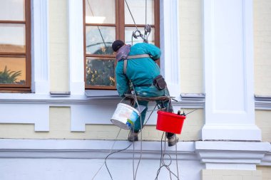 Tırmanışçı, pencereye ve onarımda olan bir binanın ön cephesine hizmet ediyor. inşaat sektörü