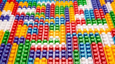 Renkli yapı bloklarının soyut arkaplan dokusu. İnşaatçının renkli plastik parçalarının arka planı. Renkli oyuncak yığınları..