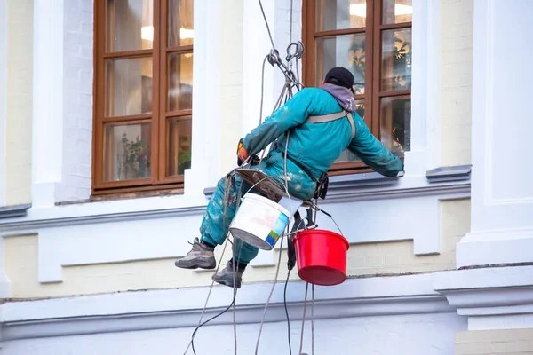 climber worker is engaged in the repair and cleaning of windows and the facade of a renovated residential building. construction business industry