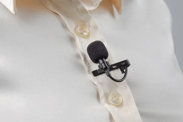 这个比较漂亮的话筒是用一个夹夹在一件女式衬衫的特写上的 冷凝器话筒上声音的录音 — 图库照片