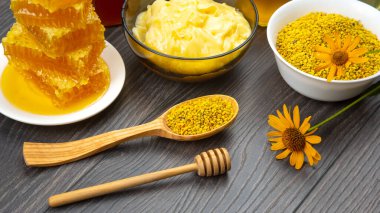 Farklı çeşitlerde taze çiçek balı, polen ve ahşap arka planda kaşıkları olan bal peteği. Organik Vitamin Sağlıklı Gıda