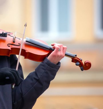 Sokak müzisyeni keman çalıyor. Müzikal yaratıcılık. Yaylı telli müzik aleti