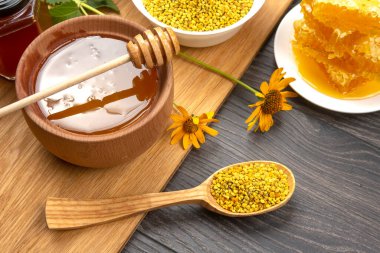 Farklı çeşitlerde taze çiçek balı, polen ve ahşap arka planda kaşıkları olan bal peteği. Organik Vitamin Sağlıklı Gıda