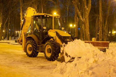 Akşamları traktörle parkta kar temizliyorum.