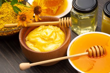 Farklı çeşitlerde taze çiçek balı, polen ve ahşap arka planda kaşıkları olan bal peteği. Organik Vitamin Sağlıklı Gıda