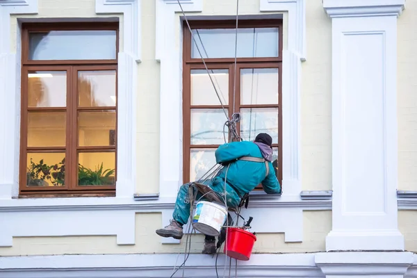 climber worker cleaning of windows and the facade of a renovated residential building. construction business industry