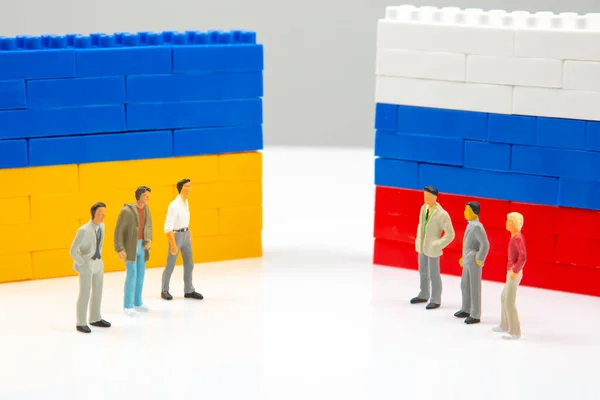 stock image Miniature people. National Ukrainian and Russian flag from colored blocks constructor. The problem of relations countries. Russian aggression against Ukraine.