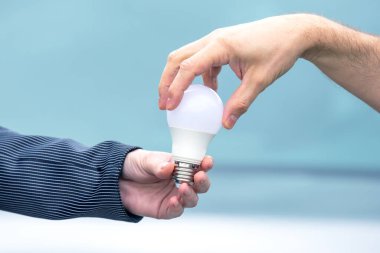 LED lamba elinde. Elektrikli bir nesneyle ışıklandırma