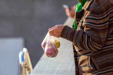 Zavallı yaşlı kadın bir çanta elma satıyor. Yaşlıların ticareti ve hayatta kalması