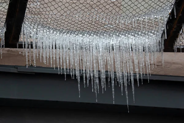 通りの家の近くのワイヤ上のつらら 冬の自然 — ストック写真