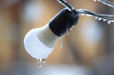 Donmuş sokak lambalarının üzerindeki buz saçakları. Kış mevsimi. Sokak içi ayrıntıları. elektrik nesnesi